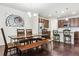 Open dining area featuring a modern chandelier and a spacious island and adjacent kitchen at 6765 S Old Hammer Ct, Aurora, CO 80016