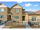 Charming townhome featuring stone accents, a fenced front yard, and solar panels on the roof at 6765 S Old Hammer Ct, Aurora, CO 80016