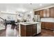 Open kitchen features a large island with seating, stainless steel appliances and access to living area at 6765 S Old Hammer Ct, Aurora, CO 80016