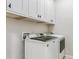 Well-lit laundry room with cabinetry above the washing machine and dryer at 6765 S Old Hammer Ct, Aurora, CO 80016