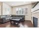 Bright living room featuring dark hardwood floors, a sectional couch, and natural light at 6765 S Old Hammer Ct, Aurora, CO 80016