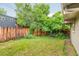 Lush backyard featuring a wooden fence, grassy area, mature trees and shrubs, and a seating bench at 1831 S Ivanhoe St, Denver, CO 80224