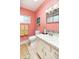 Pink bathroom featuring a white vanity, toilet, medicine cabinet and vintage-style fixtures at 1831 S Ivanhoe St, Denver, CO 80224