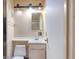 Neutral bathroom featuring a toilet, vanity, and a mirrored medicine cabinet with modern lighting at 1831 S Ivanhoe St, Denver, CO 80224