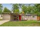 Charming home featuring a bright red front door, covered parking, and a cozy outdoor seating area at 1831 S Ivanhoe St, Denver, CO 80224