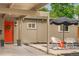 Stylish front porch seating area with an orange door providing a warm welcome to the home at 1831 S Ivanhoe St, Denver, CO 80224