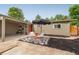 Inviting front yard features a shaded seating area and a pop of color with the red front door at 1831 S Ivanhoe St, Denver, CO 80224