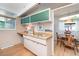 Galley kitchen featuring white cabinets and an electric cooktop and an adjacent dining area at 1831 S Ivanhoe St, Denver, CO 80224