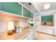 The kitchen shows vintage cabinets, countertops, and backsplash with a view into the bright living room at 1831 S Ivanhoe St, Denver, CO 80224