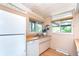 Kitchen with double sink, white cabinets, and views of the outdoors through bright windows at 1831 S Ivanhoe St, Denver, CO 80224