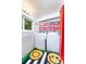 Well-lit laundry room with shelving, washer, dryer, and cheerful smiley-face mats at 1831 S Ivanhoe St, Denver, CO 80224