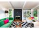 Bright living room boasts a striking black fireplace, a vivid green sofa, and large windows at 1831 S Ivanhoe St, Denver, CO 80224