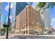 Brick building in a dense urban environment with surrounding buildings and mature trees at 444 17Th St # 1003, Denver, CO 80202