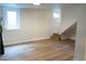 Basement featuring laminate floors, two windows, and steps leading to a closet at 3073 W Center Ave # C, Denver, CO 80219