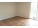 A bright bedroom featuring modern laminate floors and a sliding door to the outside at 3073 W Center Ave # C, Denver, CO 80219