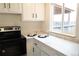 Bright kitchen with white cabinetry, black hardware and oven, and light countertops at 3073 W Center Ave # C, Denver, CO 80219
