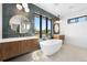 Luxurious bathroom features a soaking tub, dual vanities, and stylish fixtures under bright windows at 5358 Lions Paw St, Castle Rock, CO 80104