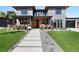 Stunning modern home with a gray brick exterior, wooden accents, and professional landscaping at 5358 Lions Paw St, Castle Rock, CO 80104