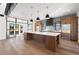 Modern kitchen with an oversized island, stainless steel fridge, and open floor plan to the living area at 5358 Lions Paw St, Castle Rock, CO 80104