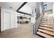 Bright, open-concept living space with hardwood floors, modern staircase, and a view of the kitchen at 5358 Lions Paw St, Castle Rock, CO 80104