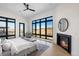 Bright bedroom with a fireplace, large windows with views, and modern ceiling fan at 5358 Lions Paw St, Castle Rock, CO 80104