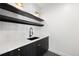 Elegant wet bar features dark cabinetry with brass hardware and open shelves at 5358 Lions Paw St, Castle Rock, CO 80104
