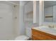 Full bathroom with tile shower, oak vanity, and storage space above toilet at 11886 Elk Head Range Rd, Littleton, CO 80127