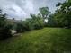 Spacious backyard with green lawn, mature trees, and partial privacy fence at 912 E 6Th Ave, Broomfield, CO 80020