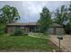 Charming ranch-style home featuring mature trees, brick accents, and a well-manicured lawn at 912 E 6Th Ave, Broomfield, CO 80020