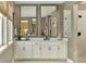 Elegant bathroom with double vanity, large mirrors, and a glass-enclosed shower at 5629 Farrier Pt, Castle Rock, CO 80104