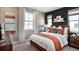 Modern bedroom featuring a king-size bed with white bedding, orange accents, and large windows for natural light at 5629 Farrier Pt, Castle Rock, CO 80104