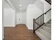 Inviting entryway with wood floors, white walls, and staircase with wood railing at 5629 Farrier Pt, Castle Rock, CO 80104