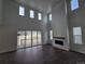 Bright living room featuring high ceilings, a cozy fireplace, and a seamless transition to the outdoor patio at 5629 Farrier Pt, Castle Rock, CO 80104