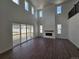 Bright and airy living room boasts soaring ceilings, a fireplace, and access to the outdoor patio at 5629 Farrier Pt, Castle Rock, CO 80104