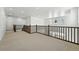 Bright loft area with carpet, white walls, and wood railing overlooking the entryway at 5629 Farrier Pt, Castle Rock, CO 80104
