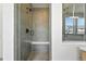 Modern shower with gray tile, built-in seat, and glass enclosure at 5629 Farrier Pt, Castle Rock, CO 80104