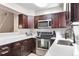Modern kitchen with stainless steel appliances, dark wood cabinets, and white countertops at 1011 Milo Cir # A, Lafayette, CO 80026