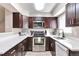 Modern kitchen with stainless steel appliances, dark wood cabinets, and white countertops at 1011 Milo Cir # A, Lafayette, CO 80026