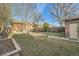 Large backyard features a lush lawn, mulch beds, brick path, and a privacy fence at 2050 S Lincoln St, Denver, CO 80210