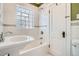 Bathroom featuring white subway tile walls with glass block window above the tub and shower at 2050 S Lincoln St, Denver, CO 80210