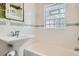 Bathroom featuring white subway tile walls with glass block window above the tub at 2050 S Lincoln St, Denver, CO 80210
