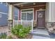 Inviting front porch with stylish door, stone accents, and a well-manicured garden at 17855 E 103Rd Ave, Commerce City, CO 80022