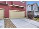 Attached garage with a concrete driveway and tan garage door, part of a red home at 17855 E 103Rd Ave, Commerce City, CO 80022