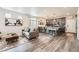 Open-concept living room with a modern kitchen and sleek hardwood floors at 17855 E 103Rd Ave, Commerce City, CO 80022
