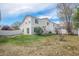 Wide backyard featuring a white fence, green grass, and a sliding glass door at 19153 E 51St Ave, Denver, CO 80249