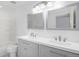 Bright bathroom with double sink vanity, modern mirrors, and shower-tub combination, offering a relaxing space at 19153 E 51St Ave, Denver, CO 80249