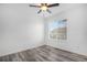 Bright bedroom with wood-look flooring, ceiling fan, and a large window overlooking the neighborhood at 19153 E 51St Ave, Denver, CO 80249