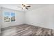 Bright bedroom with wood-look flooring, ceiling fan, and a large window overlooking the neighborhood at 19153 E 51St Ave, Denver, CO 80249