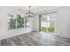 Bright dining area featuring an elegant chandelier, large windows, and sliding glass door to the backyard at 19153 E 51St Ave, Denver, CO 80249