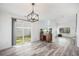 Dining area with sliding glass doors to the yard, wood-look floors, and modern chandelier at 19153 E 51St Ave, Denver, CO 80249